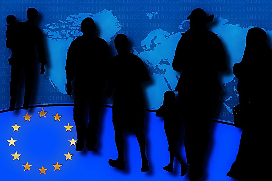 Schattenhafte Flüchtlinge vor einer Weltkarte